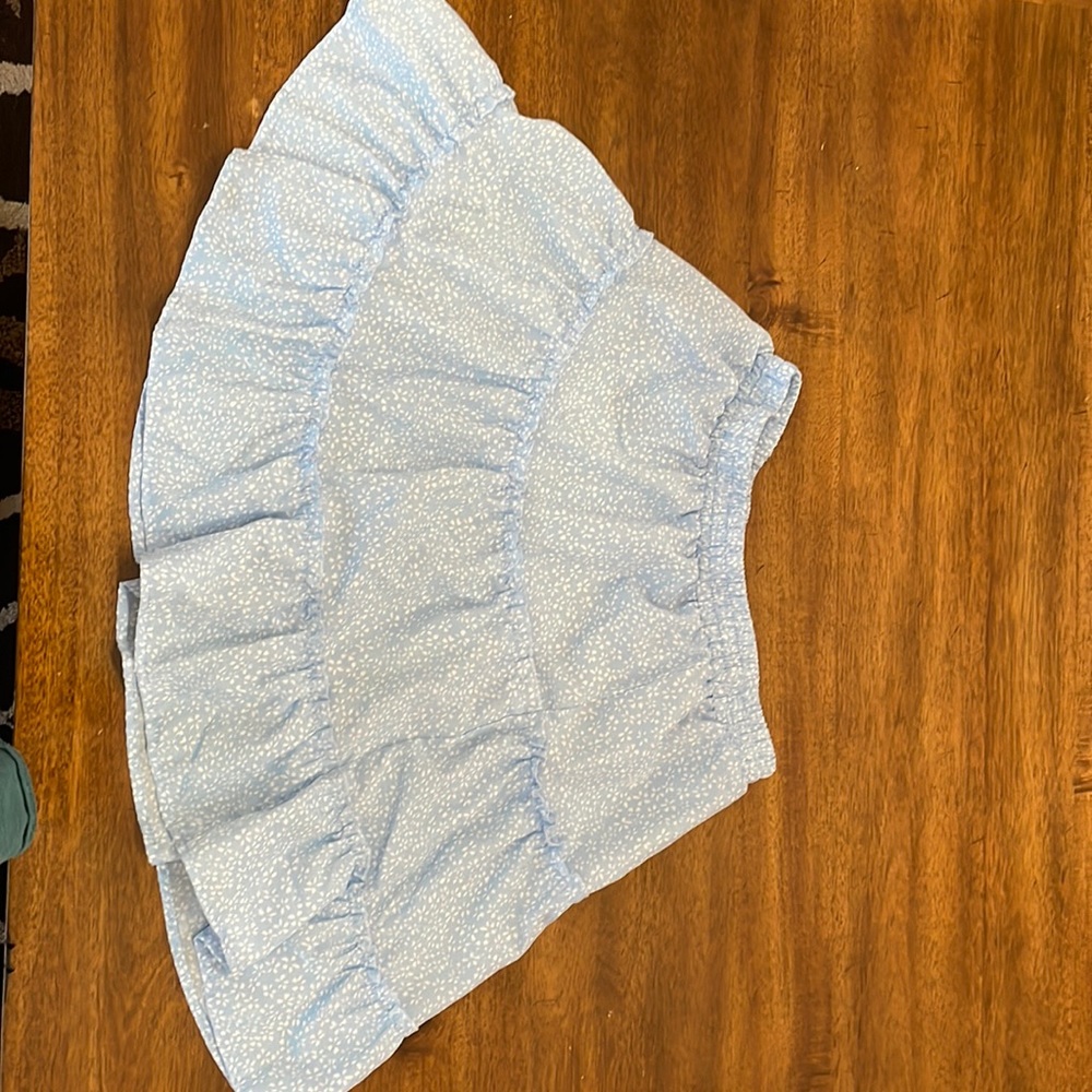 A skirt that is blue with small white flowers on it.